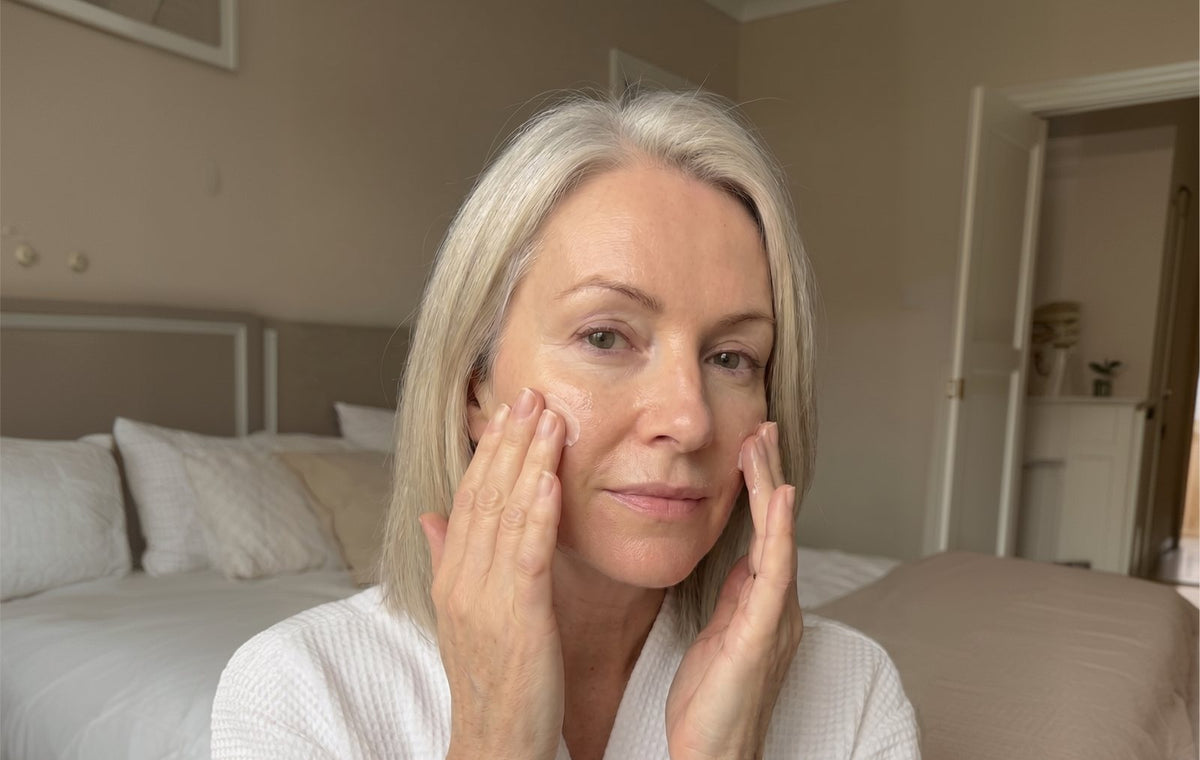 Woman applying balm to her face